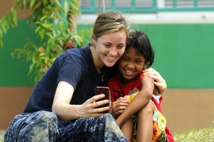A Sailor takes a photo with a Thai girl during a community service event at The Child Development and Protection Center in Huay Yai, Thailand.